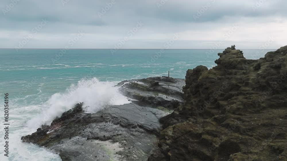 Epic waves crashing at rocky shore on Oahu island. Beautiful sea waves breaking with foams and splashes at scenic coast on Hawaii island in Pacific ocean on cloudy day. Ocean background for copy space Epic waves crashing at rocky shore on Oahu island. Beautiful sea waves breaking with foams and splashes at scenic coast on Hawaii island in Pacific ocean on cloudy day. Ocean background for copy space