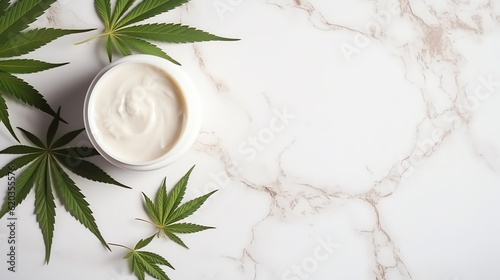Jar of cbd cream with cannabis marijuana leaves sitting on top of a marble white table. Space for text.