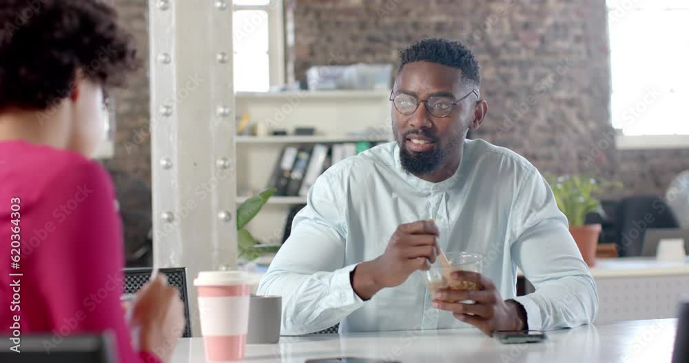 Happy diverse colleagues talking and having lunch at table in office in slow motion Happy diverse colleagues talking and having lunch at table in office in slow motion