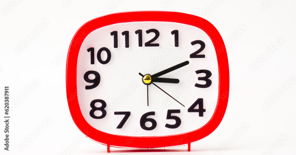 Red tabletop clock is placed on a white floor. Red tabletop clock is placed on a white floor.