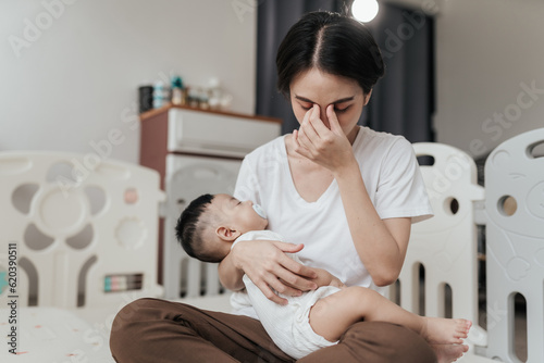 Tired Asian mother suffering from experiencing postnatal depression. Healthcare single mom motherhood stressful.