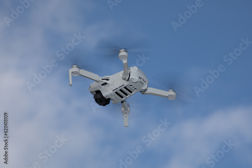 drone quadcopter with propellers uprated camera flying in blue sky background