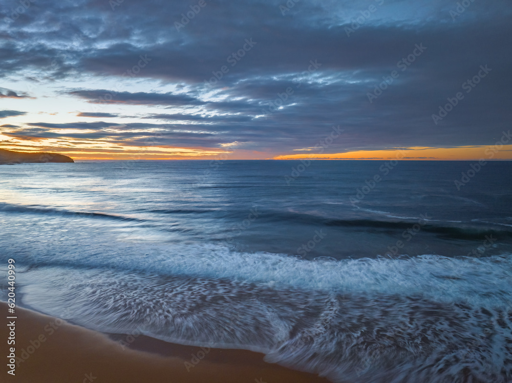 Surf, sea, sand, sunrise with clouds