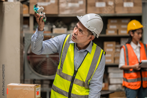 senior mananger products inspector quality control checking examination hardware electornics part before shipping or receiving in inventory store collection photo