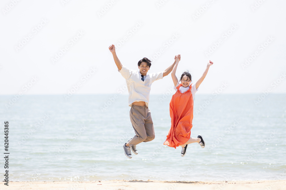 海辺でジャンプする男女 海辺でジャンプする男女
