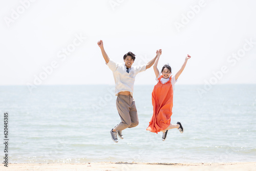 海辺でジャンプする男女