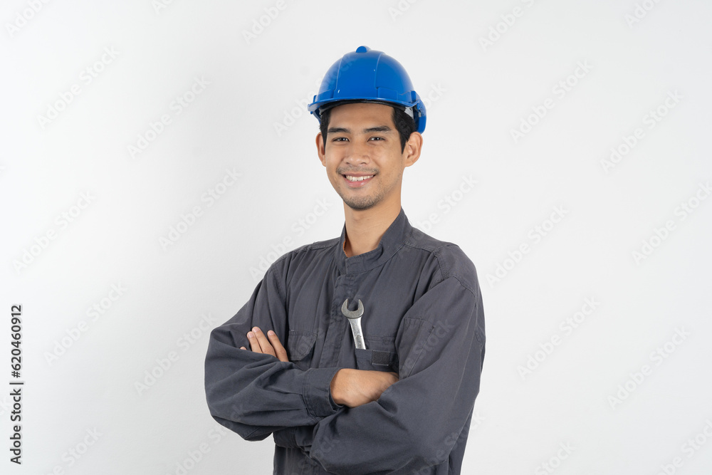Repairman mechanic, Asian young handyman holding tools and wearing blue safety helmet isolated on background.