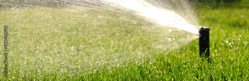 Automatic garden irrigation system watering lawn with adjustable head. Automatic equipment for irrigation and maintenance of lawns, gardening.