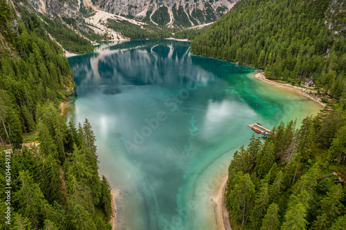 Lago di Braies surrounded by mountain ranges and pine forests in the Italian Dolomites.