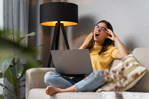 Obraz na płótnie Overworking multi-ethnic attractive woman yawning tired student working on lapto