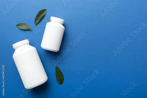 supplement pills with medicine bottle health care and medical top view. Vitamin tablets. Top view mockup bottle for pills and vitamins with green leaves, natural organic bio supplement, copy space photo