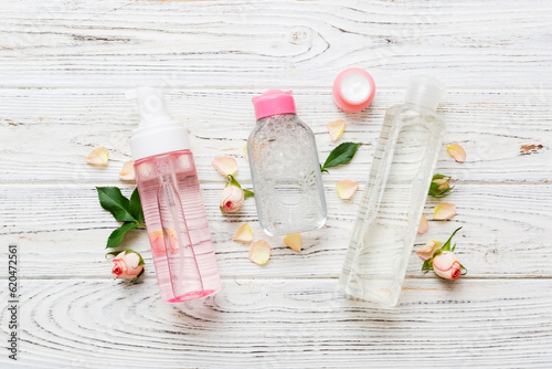 Fancy healthcare bottles for serum, micellar, tonic, toner, lotion, water and cream with rose flower. Natural oranic spa cosmetics concept. Mockup, template, Top view