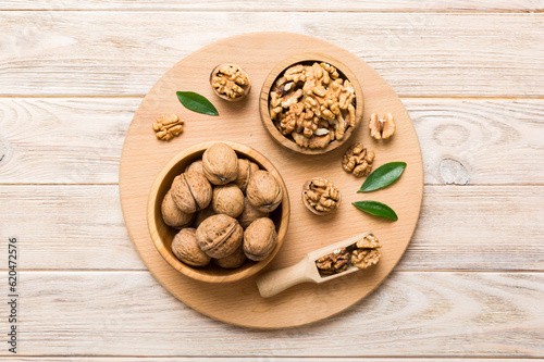 Walnut kernel halves, in a wooden bowl. Close-up, from above on colored background. Healthy eating Walnut concept. Super foods with copy space