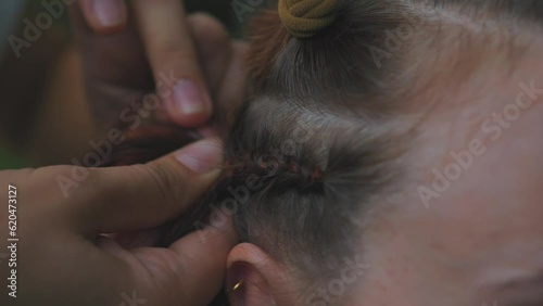 Process of weaving making boxer braids cornrows by a hair braider. photo