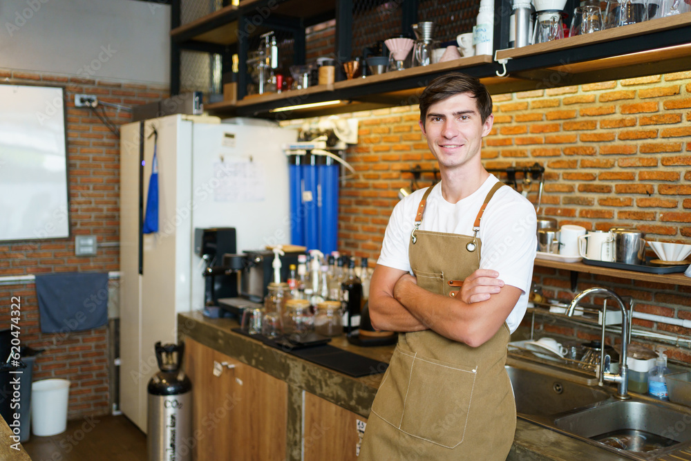 Professional young coffee barista standing inside the counter bar in