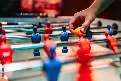 man plays table football. Detail of man's hands playing the kicker