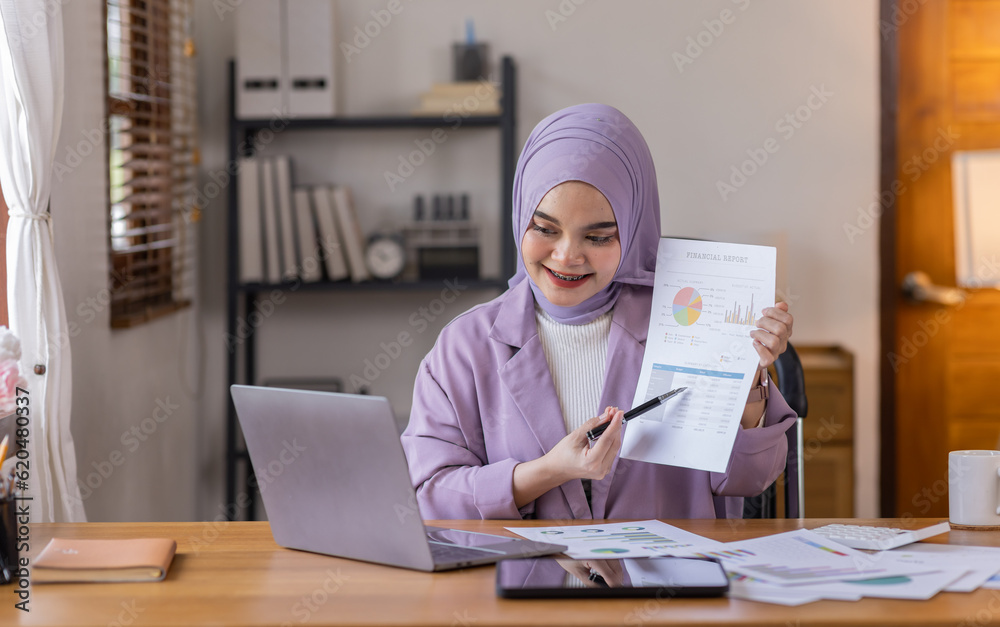 Asian business asian islamic woman in hijab holding financial documents ...