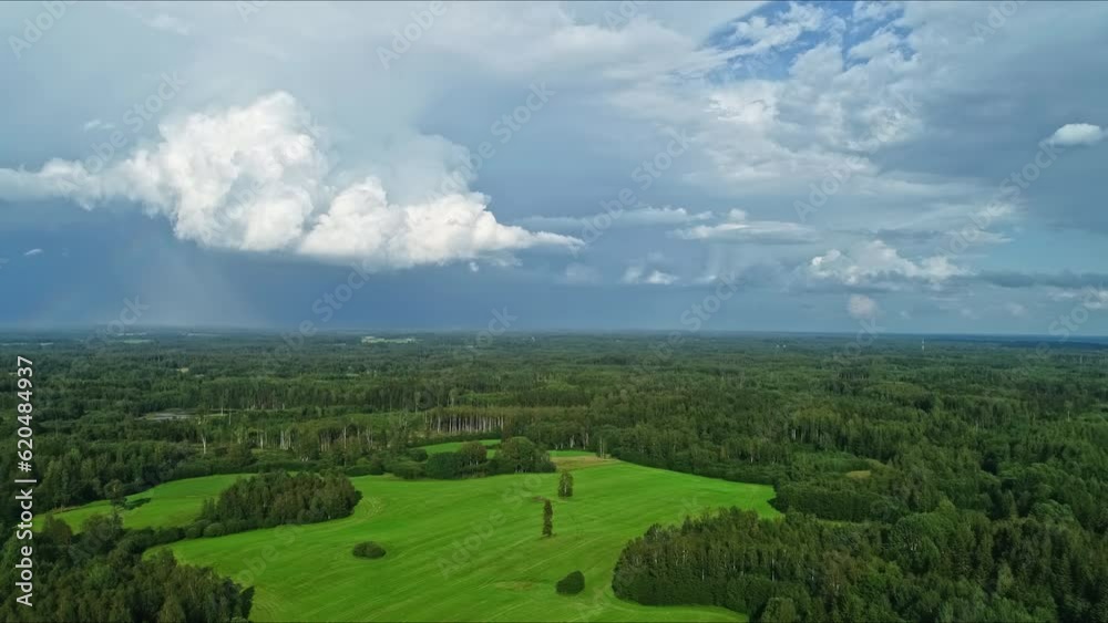 Aerial drone shot over green forest along rural countryside covered with green vegetation on a cloudy day. Aerial drone shot over green forest along rural countryside covered with green vegetation on a cloudy day.