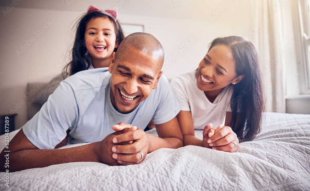 Family, relax and happy on a bed at home while laughing and playing for funny quality time. Man, woman or parents and a girl kid together in the bedroom for morning bonding with love and care