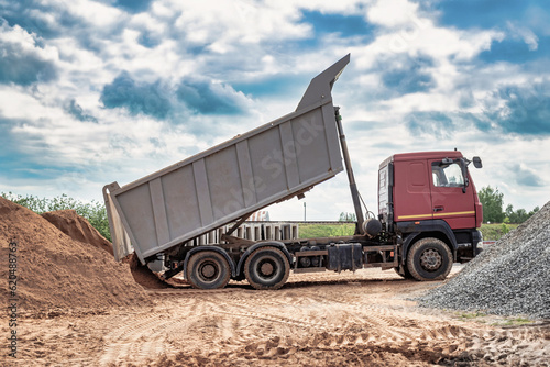 Tableau sur toile Dump truck with a raised body at a construction site