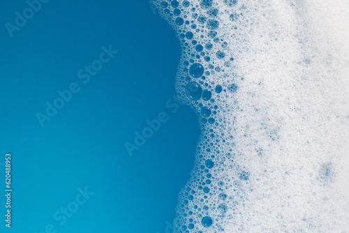 Detergent foam bubble on water. Blue background, Soap sud © Bowonpat
