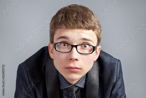 Young and suprised boy on grey background