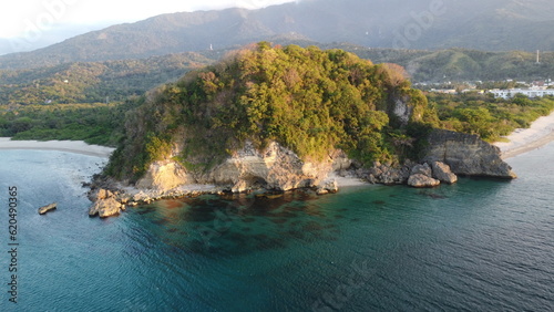 View of the sea and mountains. Stone cape and the sea. Aerial view of tropical island rocky promontory, jungle and calm sea.
