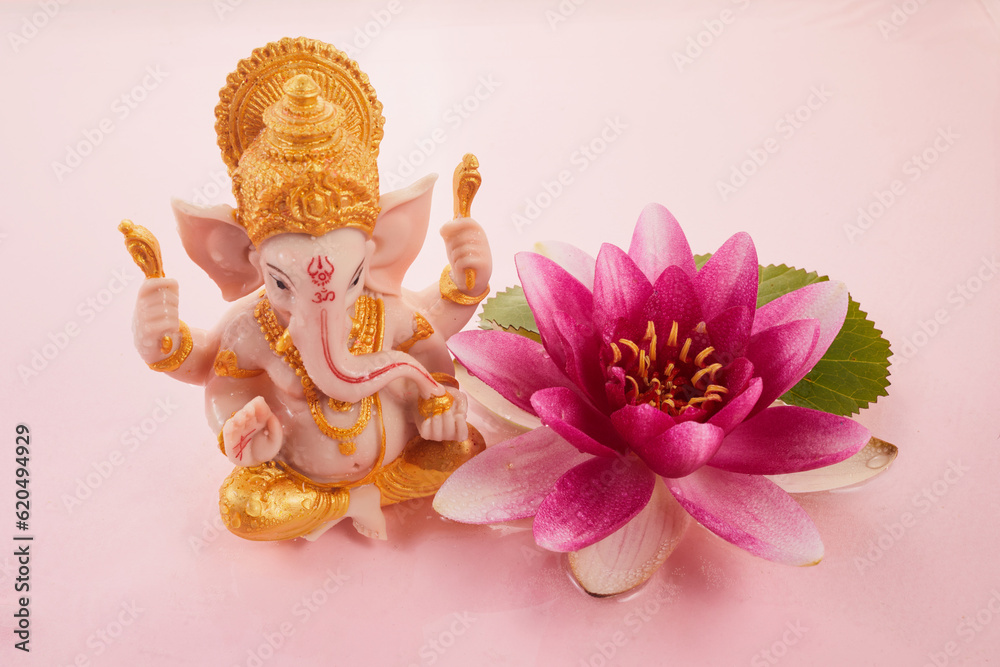 Lord ganesha sculpture in pink water with waterlily. Ganesh Chaturthi festival background