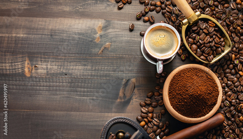 Coffee background, top view with copy space. Black cup of coffee, ground coffee, mill, bowl of roasted coffee beans on dark wooden background photo