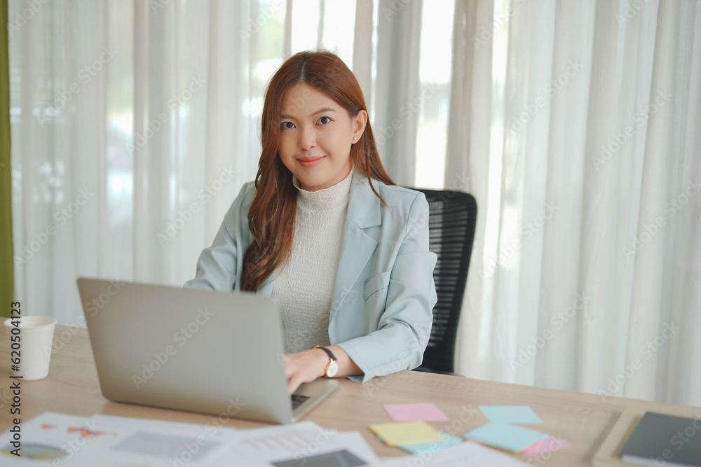 Beautiful Asian business woman working on laptop and her paperwork in the office. Beautiful Asian business woman working on laptop and her paperwork in the office.