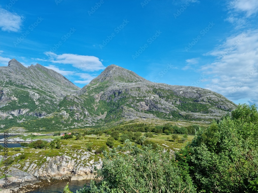 Dønnamannen mountain located on Dønna in bright sunshine, covering the length of the mountain, popular tourist attraction