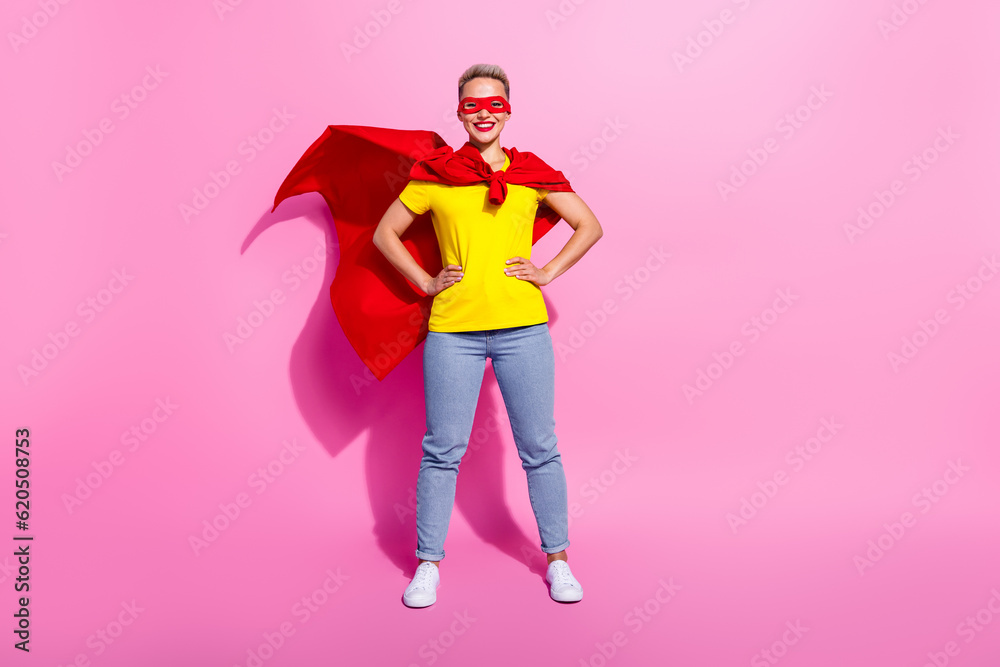 Full size portrait of positive strong super girl put hands waist wear red cape costume empty space isolated on pink color background Full size portrait of positive strong super girl put hands waist wear red cape costume empty space isolated on pink color background