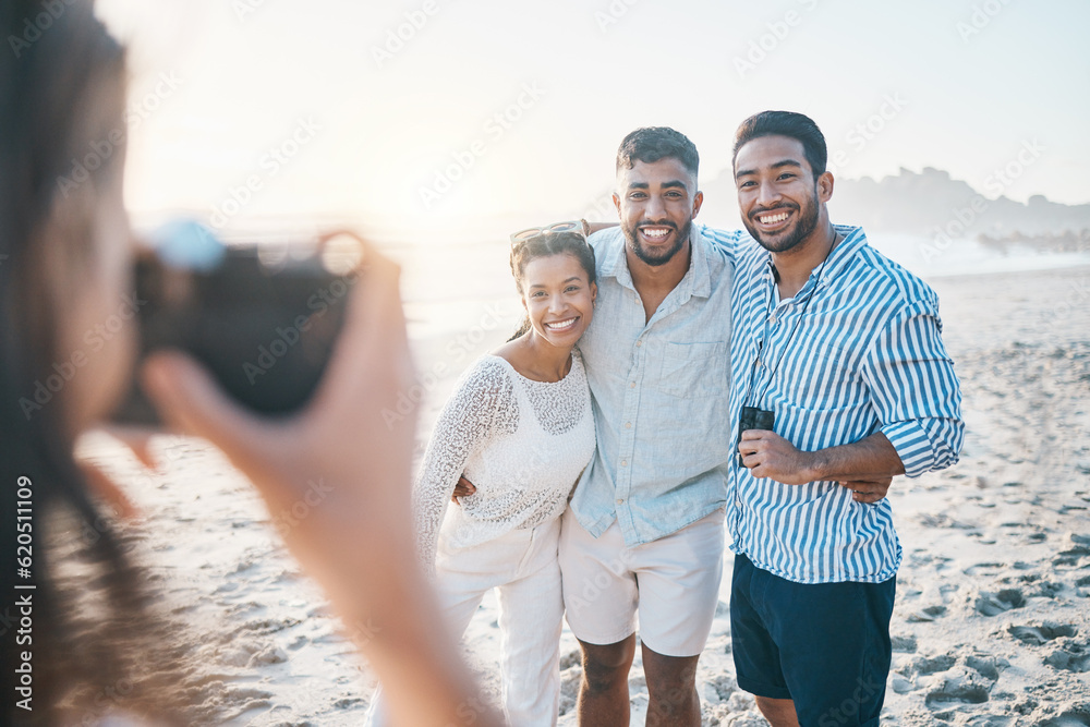 Happy, photo and friends at the beach with a photographer for summer memory, holiday or bonding. Smile, camera and a woman taking a picture of a group of people at the ocean during a vacation - obrazy, fototapety, plakaty 