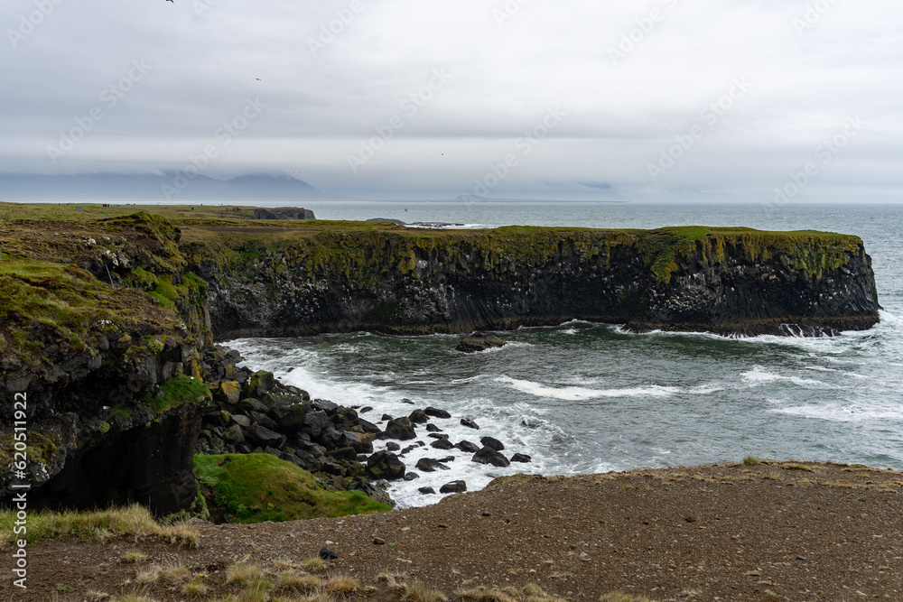 Waves washing against black basalt cliffs at Arnarstapi Cliffs in Snaefellsnes Peninsula, Iceland