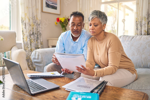 Laptop, documents and finance with a senior couple in the home living room for retirement or budget planning. Computer, accounting or investment savings with a mature man and woman in a house