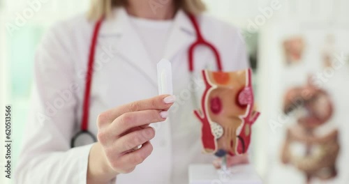 Soft suppository with laxative or for treatment of proctological diseases in hands of doctor. Proctologist and treatment of constipation in patients