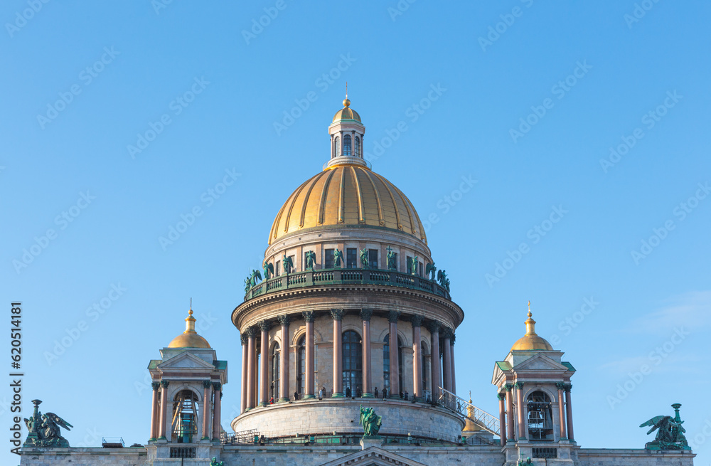 The golden dome of St. Isaac's Cathedral in St. Petersburg against the blue sky.
