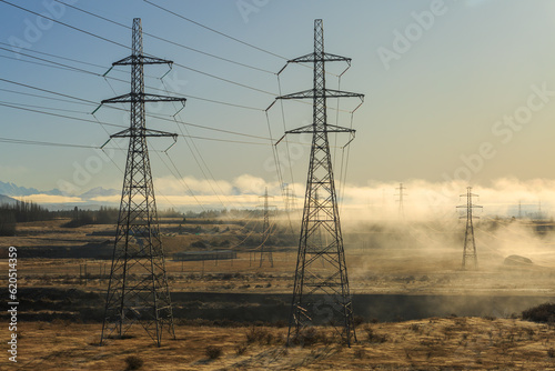 Rows of high-voltage power pylons on a misty winter morning. Photographed near the Ohau B power plant at Twizel, New Zealand photo