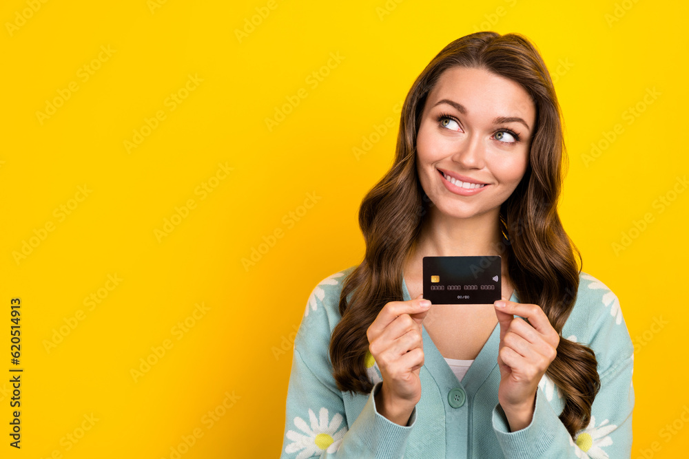 Photo of pretty positive lady hands hold plastic debit card look empty space isolated on yellow color background Photo of pretty positive lady hands hold plastic debit card look empty space isolated on yellow color background