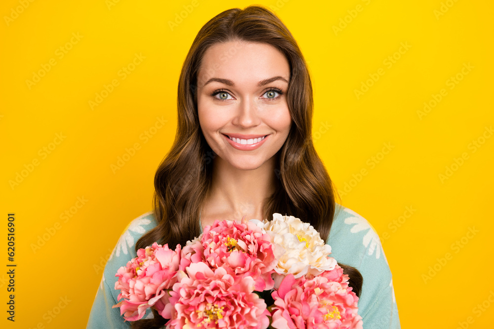Photo of dreamy adorable woman wear turquoise cardigan smiling holding flowers bunch isolated yellow color background Photo of dreamy adorable woman wear turquoise cardigan smiling holding flowers bunch isolated yellow color background