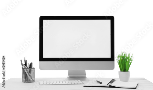 Computer, potted plant and stationery on table against white background. Stylish workplace