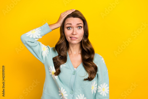 Photo of young funny clueless nervous lady wear turquoise cardigan hand head problems hesitate forgot wallet isolated on yellow color background photo