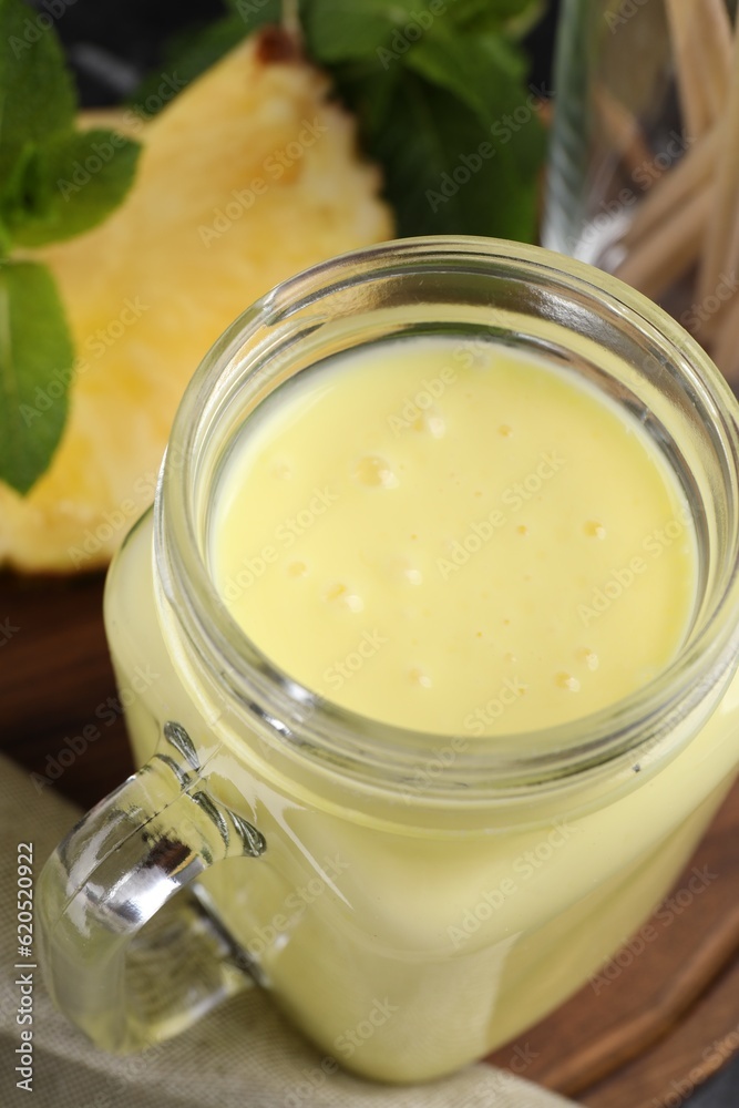 Tasty pineapple smoothie on wooden board, closeup Tasty pineapple smoothie on wooden board, closeup
