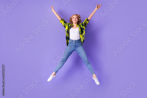 Full body photo of woman wear checkered jacket jump star active vacation relax positive shopping ad isolated on purple color background