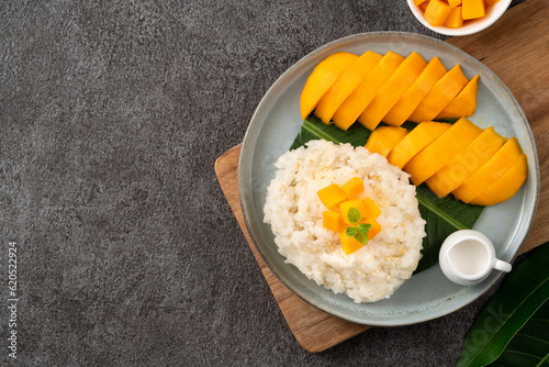 Delicious Thai mango sticky rice with cut fresh mango fruit in a plate. photo