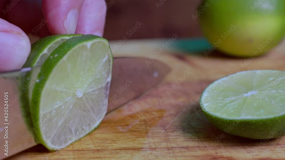 Slicing a lime on wooden cutting board