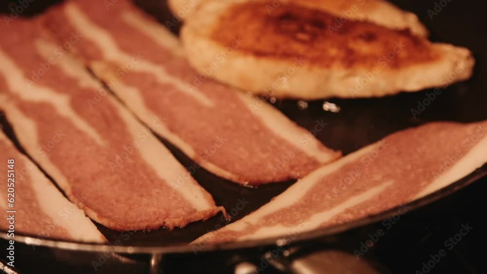 Vegan Bacon Cooking in Hot Frying Pan Next to PlantBased Chicken Fillets Vegan Bacon Cooking in Hot Frying Pan Next to PlantBased Chicken Fillets