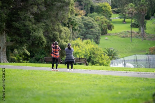 couple walking in a garden. man and woman walk in nature under trees surrounded by plants. family together in a park in spring time