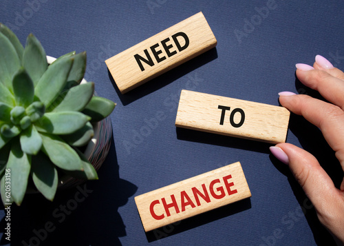 Need to change symbol. Concept words Need to change on wooden blocks. Beautiful deep blue background. Businessman hand. Business and Need to change concept. Copy space.