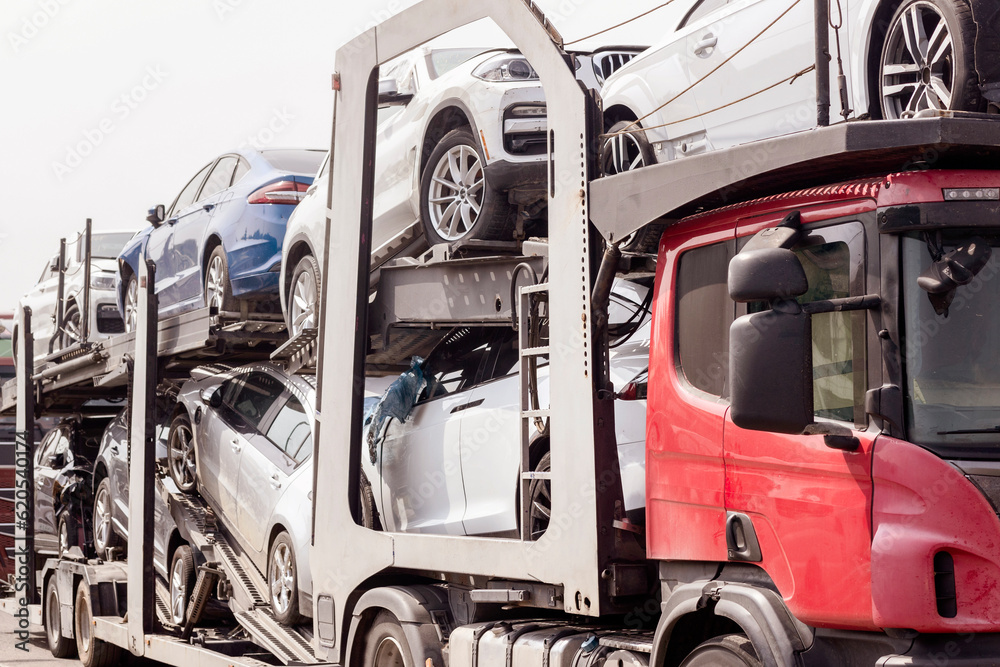 Fototapeta premium Car Carrier Transporter truck on Road. Auto Vehicles Hauler with Many Cars. Heavy Haul Trailer on Highway.